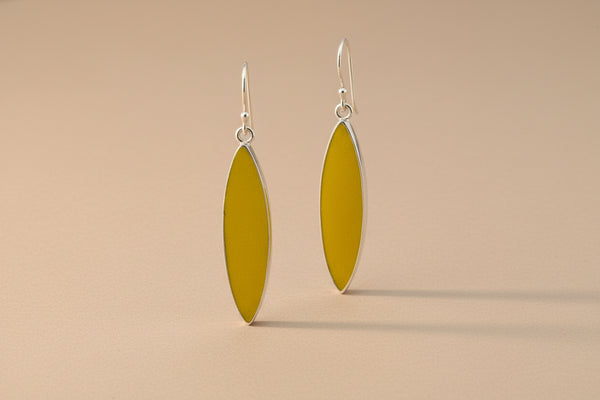 Yellow and silver earrings on a gray background
