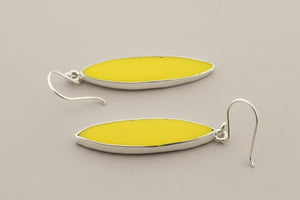 Yellow oval earrings with silver hooks on a gray background