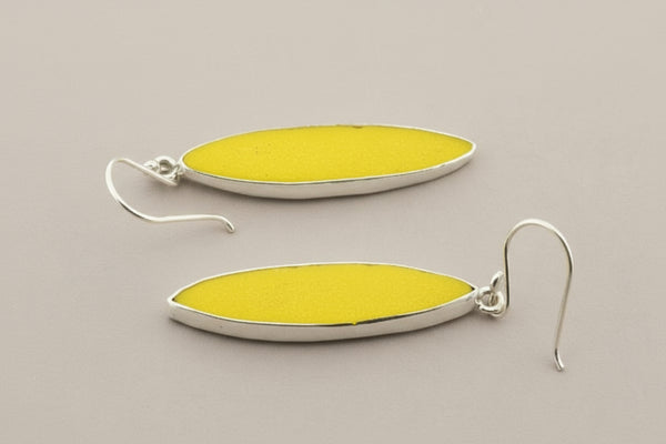 Yellow oval earrings with silver hooks on a gray background