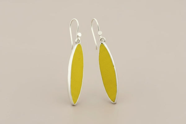 Yellow earrings with silver hooks on a gray background