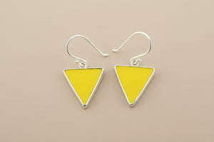 Yellow triangle earrings with silver hooks on a gray background