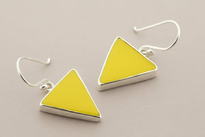 Yellow triangle earrings with silver accents on a gray background
