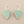 Load image into Gallery viewer, Pair of triangle-shaped earrings with light green stones on a gray background
