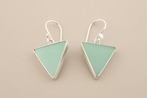 Pair of triangle-shaped earrings with light green stones on a gray background
