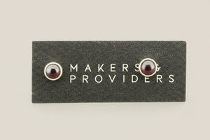 Pair of earrings on a 'Makers & Providers' card against a white background