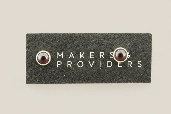 Pair of earrings on a 'Makers & Providers' card against a white background