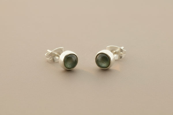 Pair of silver stud earrings on a gray background