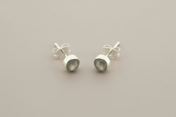 Pair of silver earrings on a gray background
