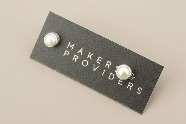 Pearl earrings on a 'Makers & Providers' card against a gray background