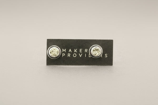 Pair of earrings on a 'Maker Providers' card against a gray background