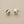 Load image into Gallery viewer, Pair of silver stud earrings with green gemstones on a gray background

