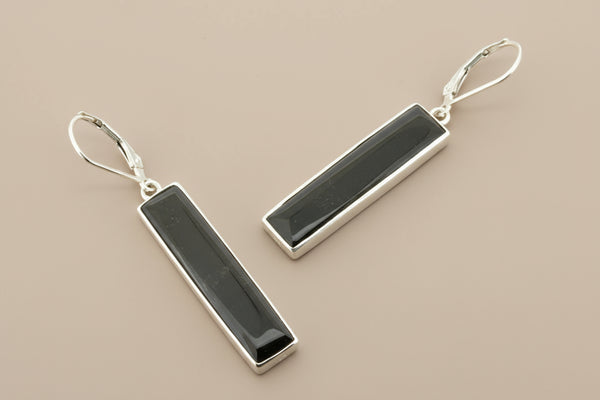 Pair of black bar earrings on a gray background