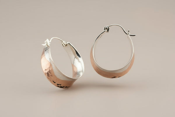 Pair of silver hoop earrings on a gray background