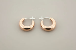 Copper & silver hoop earrings on a gray background