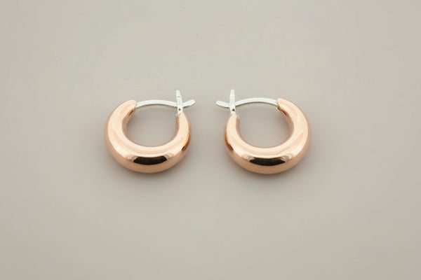 Copper & silver hoop earrings on a gray background