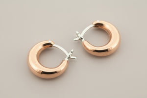 Copper & silver hoop earrings on a gray background