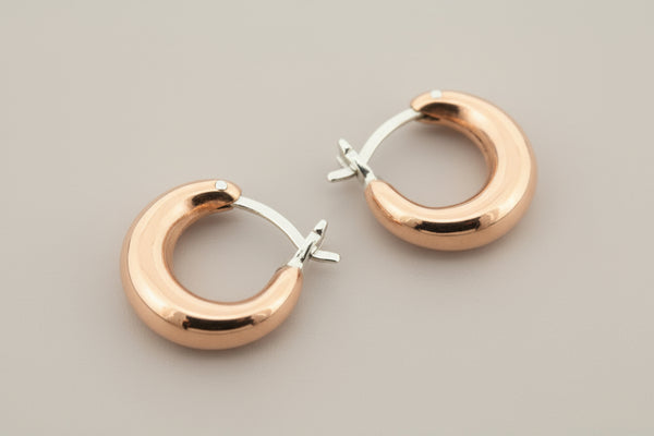 Copper & silver hoop earrings on a gray background