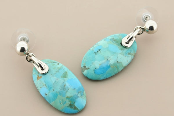 Turquoise earrings with silver  posts on a gray background