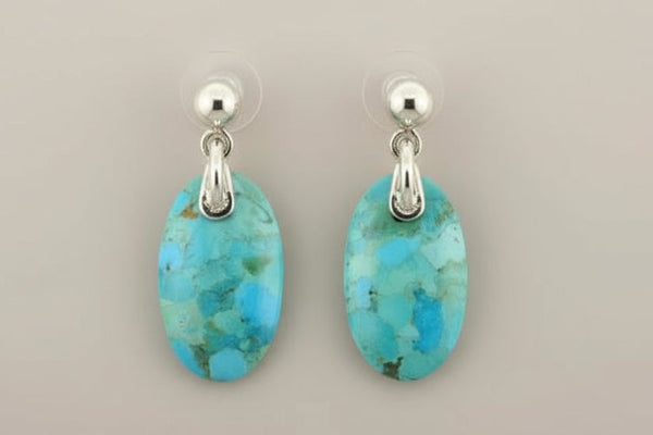 Turquoise earrings with silver hooks on a gray background