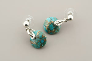 Turquoise stone earrings with silver hooks on a gray background
