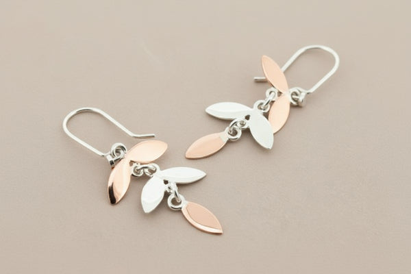 Pair of leaf-shaped earrings on a gray background