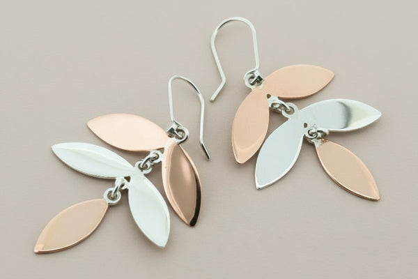 Pair of leaf-shaped earrings on a dark background