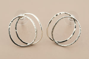 Pair of silver hoop earrings on a gray background