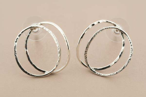 Pair of silver hoop earrings on a gray background