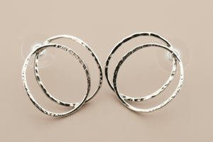 Pair of silver hoop earrings on a gray background