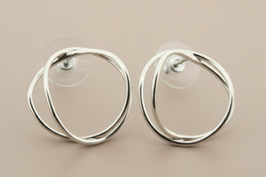 Pair of silver hoop earrings on a gray background