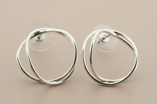 Pair of silver hoop earrings on a gray background