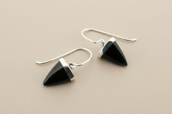 Black triangle earrings with silver hooks on a gray background