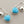 Load image into Gallery viewer, Pair of silver earrings with turquoise stones on a gray background
