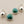 Load image into Gallery viewer, Silver earrings with green gemstones on a gray background
