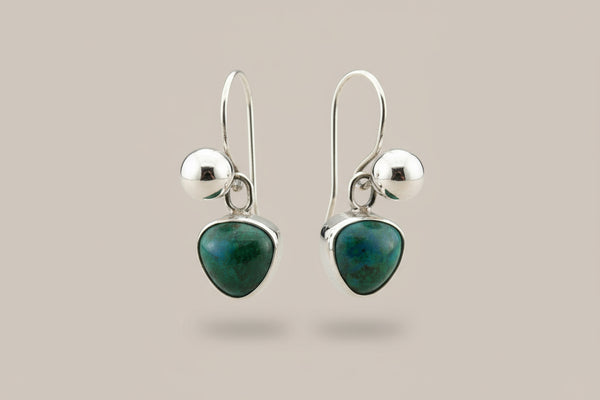 Pair of silver earrings with green gemstones on a gray background