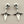 Load image into Gallery viewer, Pair of silver skull and star-shaped earrings on a beige background
