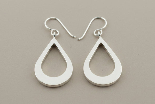 Pair of silver teardrop earrings on a gray background