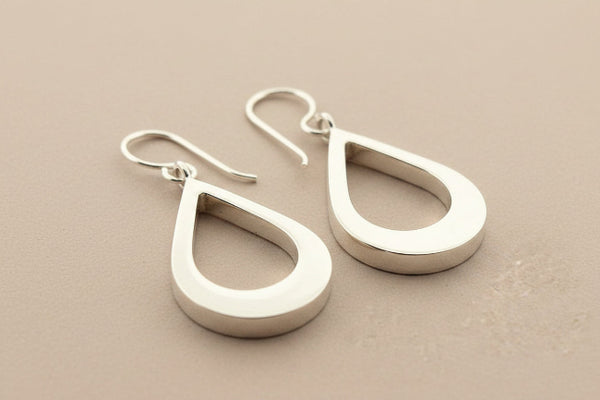 Pair of silver teardrop earrings on a gray background
