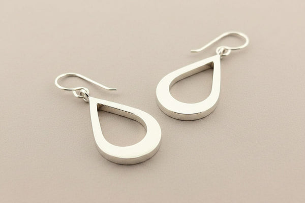 Pair of silver teardrop earrings on a gray background