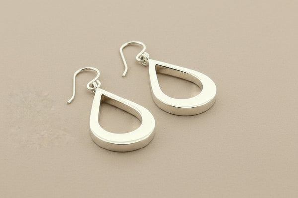 Pair of silver teardrop earrings on a gray background