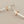 Load image into Gallery viewer, Pair of silver and rose gold earrings on a gray background

