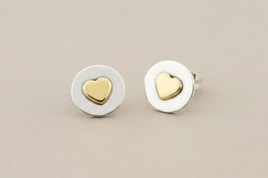 Pair of heart-shaped stud earrings on a gray background