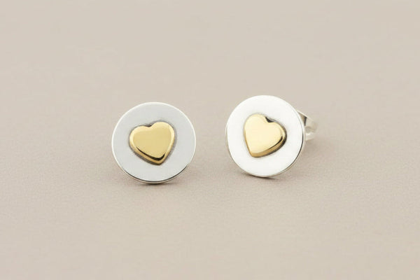 Pair of heart-shaped stud earrings on a gray background