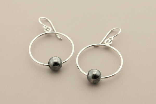 Silver hoop earrings on a gray background