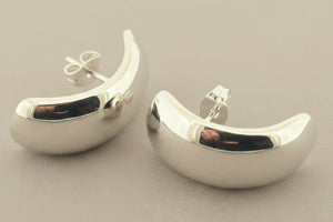 Pair of silver earrings on a gray background