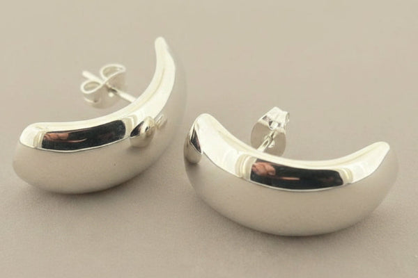 Pair of silver earrings on a gray background