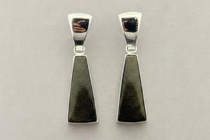 Pair of silver earrings with greenstone pendants on a gray background