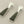 Load image into Gallery viewer, Pair of earrings with green stone and silver metal on a gray background
