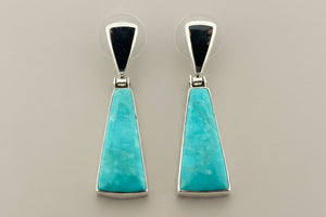 Pair of turquoise earrings on a gray background