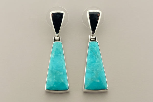 Pair of turquoise earrings on a gray background